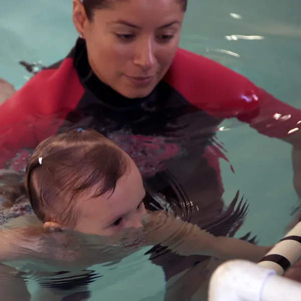 Sandra Koury teaching a child to float during a swim lesson